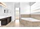 Bright bathroom featuring a soaking tub, dark cabinetry, and a dual sink vanity at 7710 Linkside Loop, Reunion, FL 34747