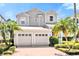 Charming two-story home features a two-car garage and mature landscaping, including palm trees at 7710 Linkside Loop, Reunion, FL 34747