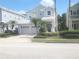 Two-story home with a two-car garage, manicured lawn, and lush landscaping at 7710 Linkside Loop, Reunion, FL 34747