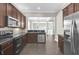 Modern kitchen boasts dark cabinets, stainless steel appliances, and a view into the living area at 7710 Linkside Loop, Reunion, FL 34747