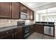 Kitchen featuring stainless steel appliances, dark cabinetry, and stone countertops at 7710 Linkside Loop, Reunion, FL 34747