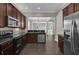 Kitchen featuring stainless steel appliances, dark cabinetry, and stone countertops at 7710 Linkside Loop, Reunion, FL 34747