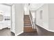 Interior staircase with dark wood-look floors, iron railing and white walls at 7710 Linkside Loop, Reunion, FL 34747