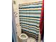 Bathroom with a toilet and a striped shower curtain at 7900 S Orange Blossom Trail # 2041, Orlando, FL 32809