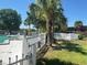 View of the swimming pool area surrounded by a white picket fence, palm trees and lawn at 7900 S Orange Blossom Trail # 2041, Orlando, FL 32809
