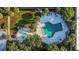 Aerial view of a unique pool area with a geometrical pool design, lush greenery, and lounge seating at 7900 S Orange Blossom Trail # 2041, Orlando, FL 32809