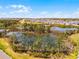 Beautiful aerial view of a community with a pond and manicured landscape at 809 Benoi Dr, Davenport, FL 33896