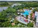 Beautiful aerial view of a community pool and splashpad, surrounded by lush landscaping and a nearby lake at 809 Benoi Dr, Davenport, FL 33896