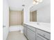 A clean bathroom with a tile shower/tub, tile floors, and gray vanity at 809 Benoi Dr, Davenport, FL 33896