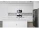 Bright kitchen features white cabinets, stainless steel appliances, and a large island with quartz countertops at 809 Benoi Dr, Davenport, FL 33896