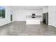 Open concept kitchen with white cabinets, quartz countertops, stainless steel appliances, and wood-look floors at 809 Benoi Dr, Davenport, FL 33896