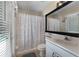 Bathroom with a shower/tub combo with seashell curtain, white vanity with sink and a mirror at 821 Shallow Brook Ave, Winter Springs, FL 32708