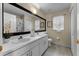 Bright bathroom featuring double sinks with white cabinetry, tile flooring and framed mirror at 821 Shallow Brook Ave, Winter Springs, FL 32708