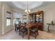 Elegant dining room with a tray ceiling, decorative chandelier, and a large china cabinet at 821 Shallow Brook Ave, Winter Springs, FL 32708