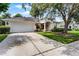 Inviting single-Gathering home featuring a well-kept lawn, driveway, garage, and a charming arched entrance at 821 Shallow Brook Ave, Winter Springs, FL 32708
