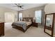 Spacious primary bedroom with neutral carpet, ceiling fan, and natural light at 821 Shallow Brook Ave, Winter Springs, FL 32708