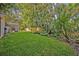 Grassy backyard with tropical foliage and view of screened patio at 828 Timber Court Ct, Apopka, FL 32712