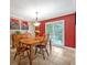 Bright dining area with a wooden table, bright red accent wall, natural light, and stylish decor at 828 Timber Court Ct, Apopka, FL 32712