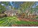 Charming brick home featuring a well-manicured lawn and lush tropical landscaping at 828 Timber Court Ct, Apopka, FL 32712