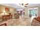 Spacious living room showcasing tile flooring, a cozy recliner, accent table and seamless flow to dining area at 828 Timber Court Ct, Apopka, FL 32712
