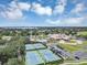 Aerial view showcasing the community's clubhouse, tennis courts, and scenic pond on a sunny day at 8430 Woburn Ct, Windermere, FL 34786