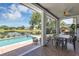 Inviting back porch overlooking pool, lake, play set, and outdoor dining area at 8430 Woburn Ct, Windermere, FL 34786