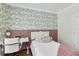 Cozy bedroom with decorative wallpaper and accents, featuring a study desk and chair at 8430 Woburn Ct, Windermere, FL 34786