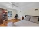 Bright bedroom featuring wood floors, a bookcase, a window with shutters, and a black chair at 8430 Woburn Ct, Windermere, FL 34786