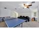 Spacious bonus room featuring a ping pong table, dark sofa, and ceiling fan at 8430 Woburn Ct, Windermere, FL 34786