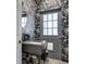 Unique powder room showcasing bold floral wallpaper and a modern vessel sink and stylish door at 8430 Woburn Ct, Windermere, FL 34786