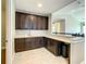 A bar area featuring wooden cabinets, quartz countertops, and modern hardware at 8491 Pippen Dr, Orlando, FL 32836