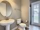 Well-lit bathroom featuring a pedestal sink, oval mirror, and standard toilet at 8491 Pippen Dr, Orlando, FL 32836