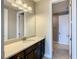 Bathroom features a white speckled countertop, dark cabinets, and a large mirror at 8491 Pippen Dr, Orlando, FL 32836