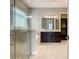 Bright bathroom featuring a glass-enclosed shower, soaking tub, and vanity with dark wood cabinets at 8491 Pippen Dr, Orlando, FL 32836