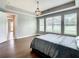 Spacious bedroom featuring hardwood floors, a tray ceiling with a modern light fixture, and bright, natural light at 8491 Pippen Dr, Orlando, FL 32836