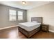 Cozy bedroom featuring a wood bed frame, hardwood floors, and natural light from the window at 8491 Pippen Dr, Orlando, FL 32836