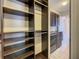 Walk-in closet providing ample storage space with shelves, hanging rods, next to laundry room at 8491 Pippen Dr, Orlando, FL 32836