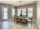 Bright dining room with modern lighting, neutral walls, and a view to the backyard through shuttered windows at 8491 Pippen Dr, Orlando, FL 32836