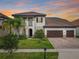 A beautiful home with a lush front lawn and an attached three-car garage at sunset at 8491 Pippen Dr, Orlando, FL 32836