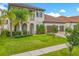 Charming home featuring a well-manicured lawn, a three-car garage, and tropical landscaping at 8491 Pippen Dr, Orlando, FL 32836