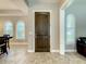 Beautiful foyer featuring dark wood door, tile flooring, and bright windows with white plantation shutters at 8491 Pippen Dr, Orlando, FL 32836