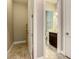 Hallway leading to bathroom with dark cabinets and marble floors at 8491 Pippen Dr, Orlando, FL 32836