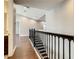 Hallway with hardwood floors, wrought iron railing, and neutral paint at 8491 Pippen Dr, Orlando, FL 32836