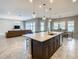 Open-concept kitchen featuring a large island, modern appliances, and seamless flow into the living and dining areas at 8491 Pippen Dr, Orlando, FL 32836