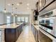 Well-lit kitchen featuring stainless steel appliances, dark cabinets, and a view into the dining area at 8491 Pippen Dr, Orlando, FL 32836