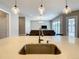 Close-up view of the kitchen island featuring a stainless steel sink, pendant lighting, and open layout at 8491 Pippen Dr, Orlando, FL 32836