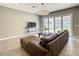 Spacious living room with tile floors, modern chandelier, and sliding glass doors to the backyard at 8491 Pippen Dr, Orlando, FL 32836