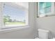 Bright bathroom features a white toilet and a window with a view at 8500 Iron Mountain Trl, Windermere, FL 34786