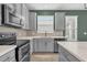 Well-equipped kitchen featuring gray cabinetry, stainless steel appliances, and a mosaic backsplash at 8500 Iron Mountain Trl, Windermere, FL 34786