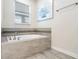 Bathroom showcases a large bathtub with gray tile surround, sleek fixtures, and a bright window at 8807 Interlocking Ct, Davenport, FL 33896